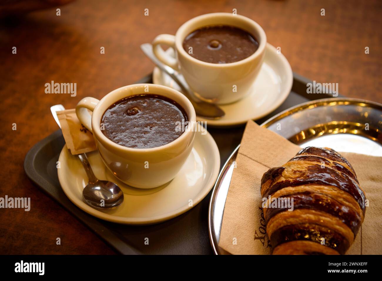 Einige Besucher trinken Schokolade im Geschäft Xocolates Pirineus in Puigcerdà (Cerdanya, Girona, Katalonien, Spanien) Stockfoto