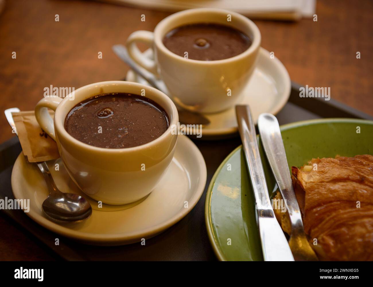 Einige Besucher trinken Schokolade im Geschäft Xocolates Pirineus in Puigcerdà (Cerdanya, Girona, Katalonien, Spanien) Stockfoto