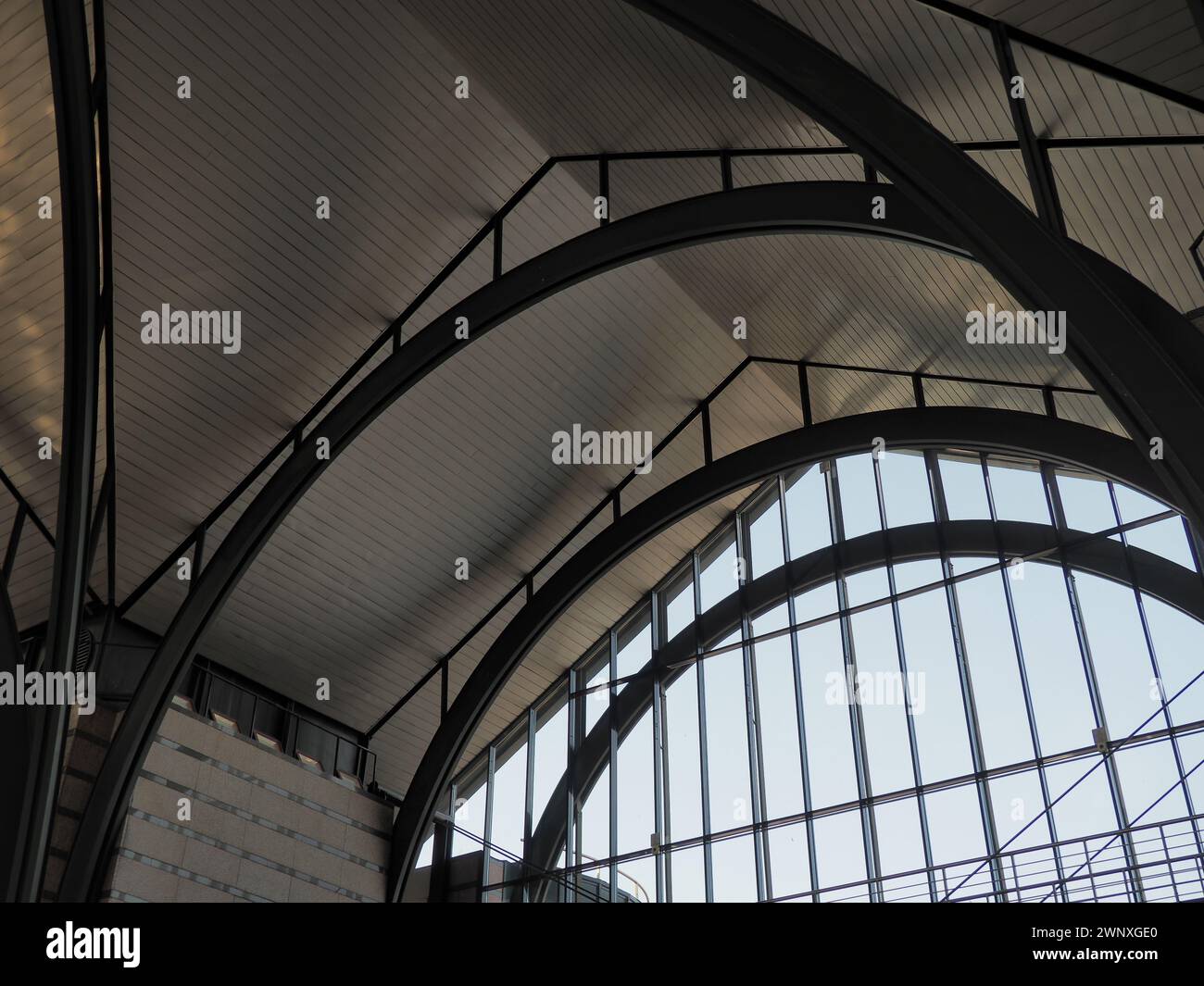 Bögen und Bögen des Bahnhofs. Metallkonstruktionen unter dem Dach eines großen Gebäudes. Konstruktionsträger und Träger. Gotische Bögen im Innenbereich. Stockfoto