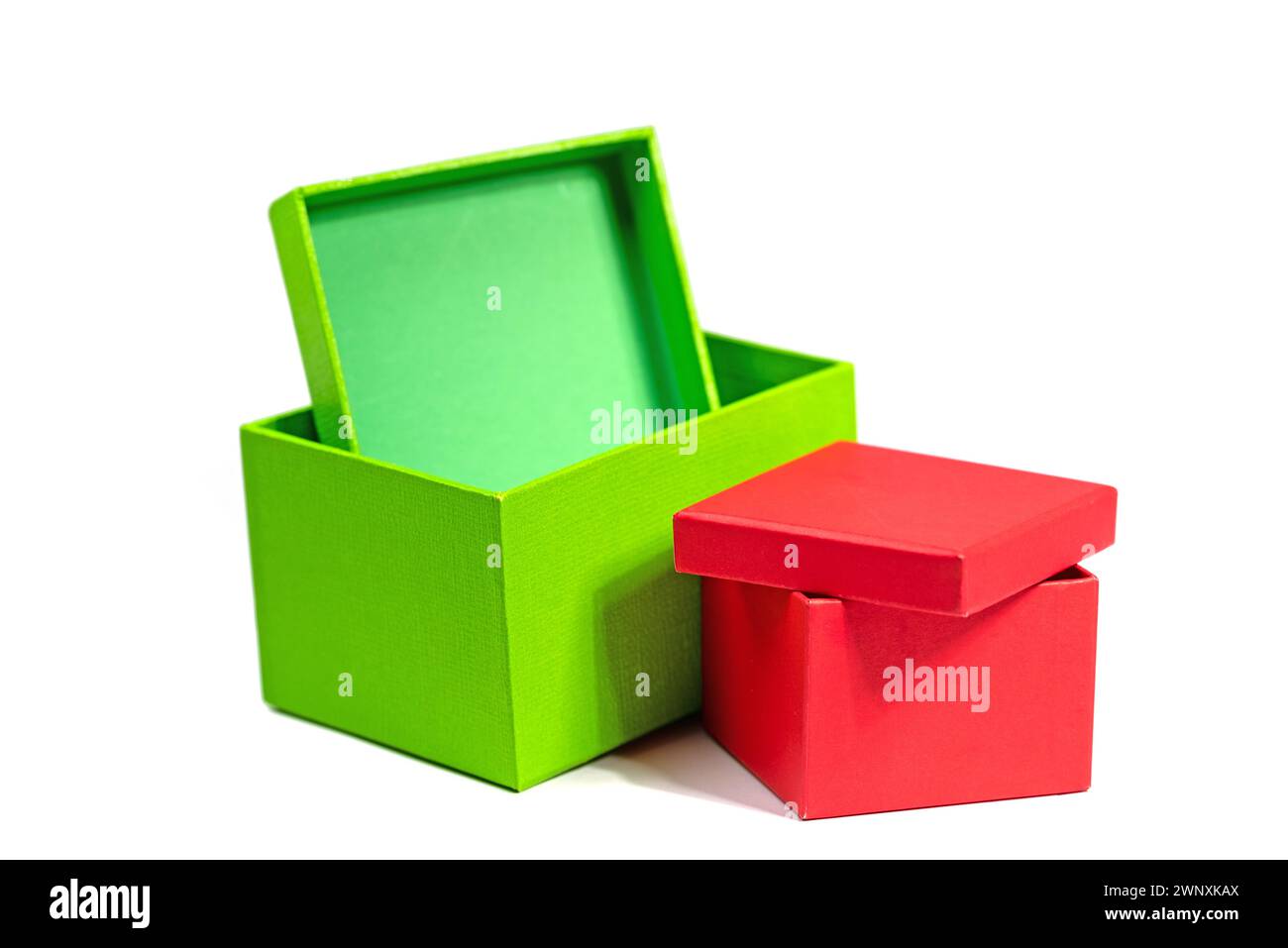 Rote und grüne Kartonschachteln vor weißem Hintergrund Stockfoto