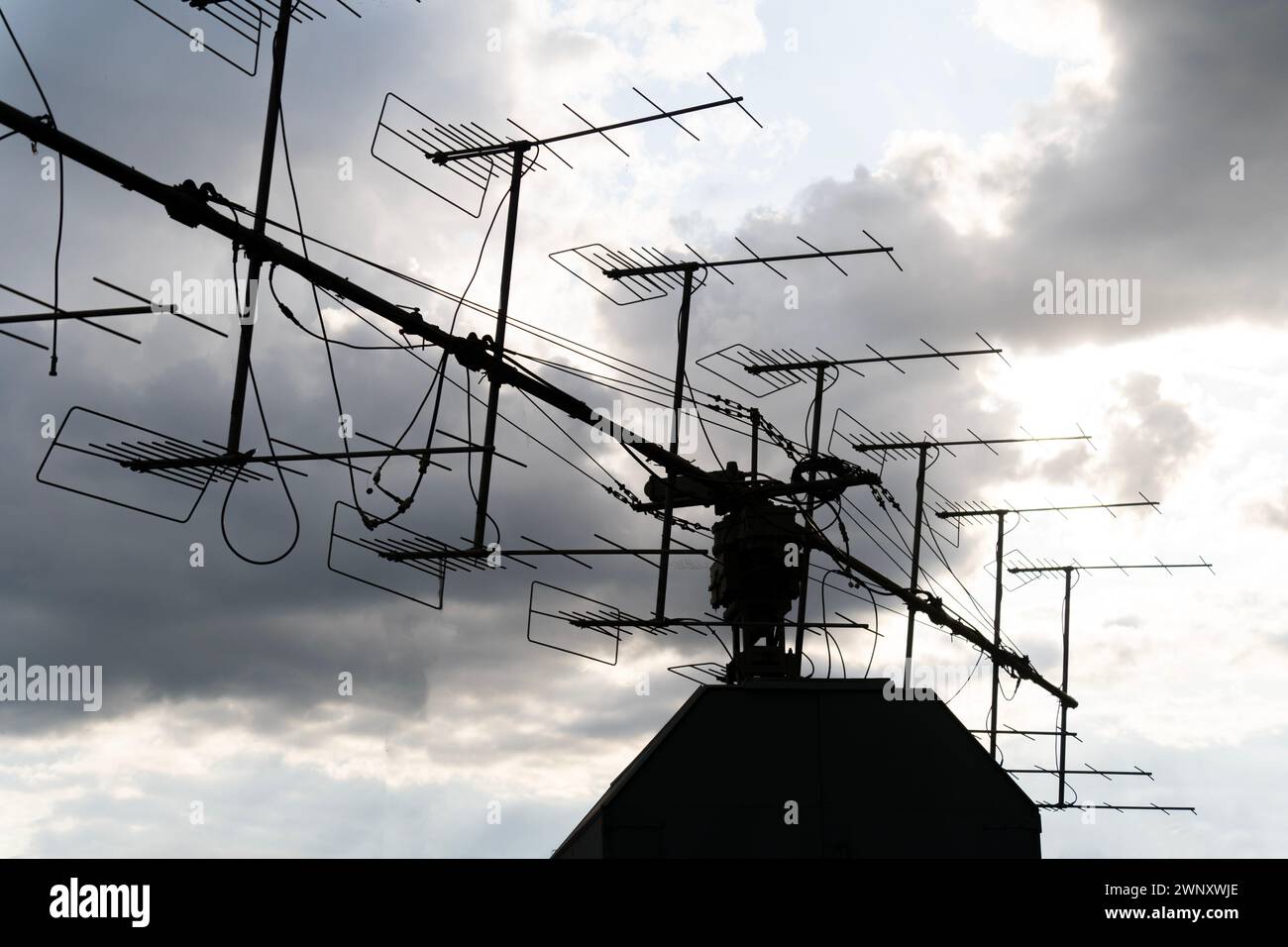 Silhouette alter Militärantennen vor bewölktem Himmel Stockfoto