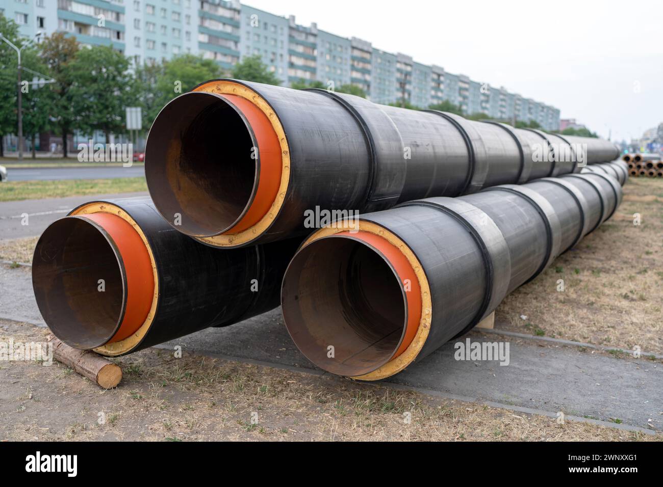 Stahlrohr mit Wärmedämmung. Neue schwarz isolierte Stahlrohre auf kommunaler Baustelle im Freien. Stockfoto