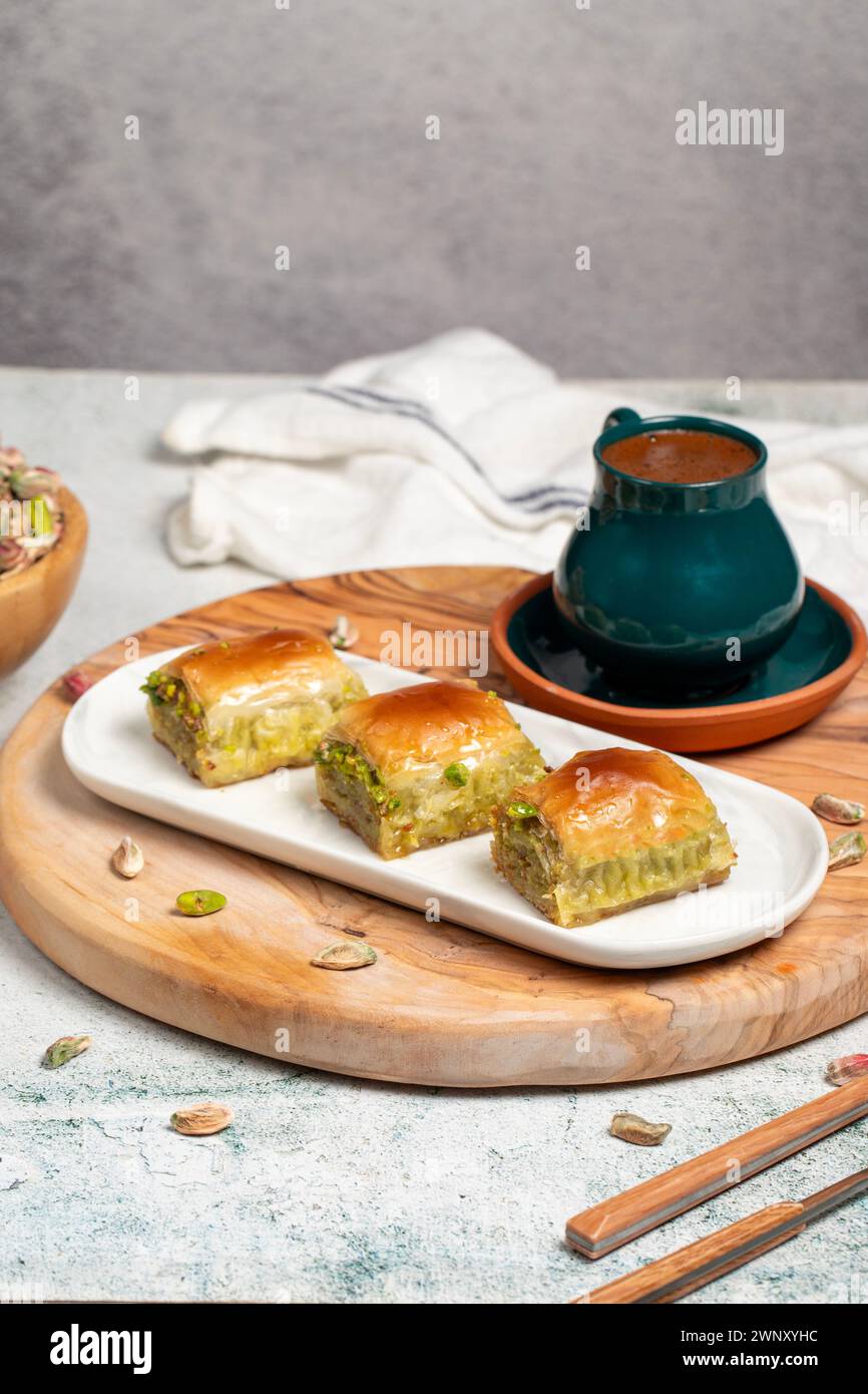 Pistazien-Baklava mit türkischem Kaffee auf rustikalem Tisch, ramadan- oder Urlaubsdesserts-Konzept. Gerichte der nahöstlichen Küche. Nahaufnahme Stockfoto