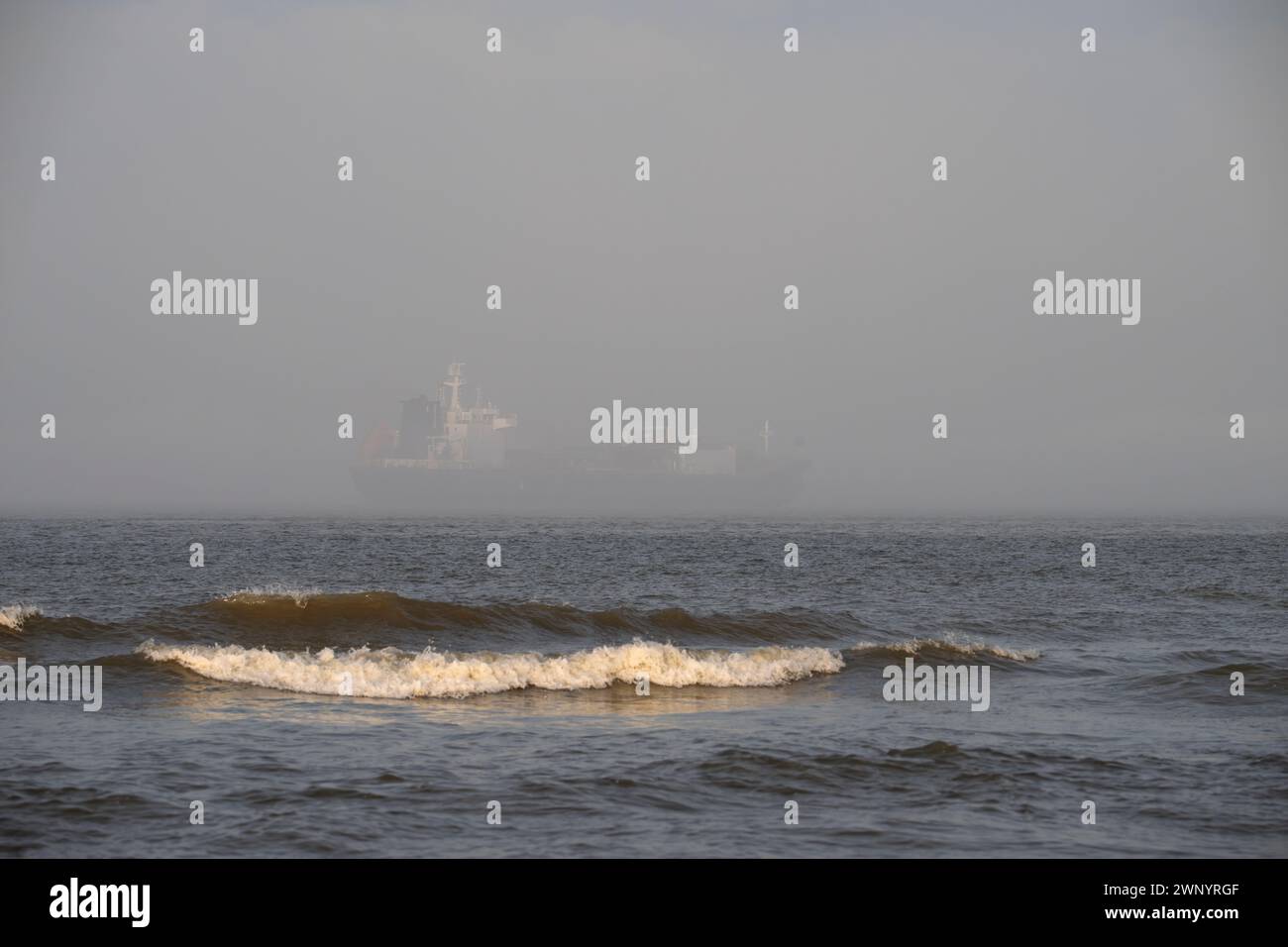 Frachtschiff verlässt den Hafen von Galveston in einem Streifen von dichtem Nebel Stockfoto