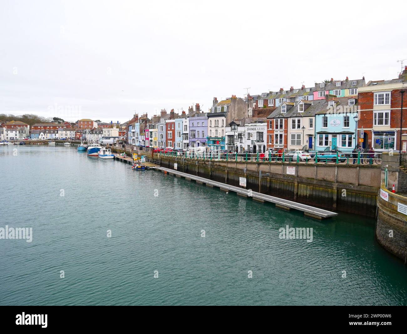 Fischerboote auf dem Fluss am Weymouth Harbour in Dorset, England mit alten Gebäuden entlang der Trinity Road. Stockfoto