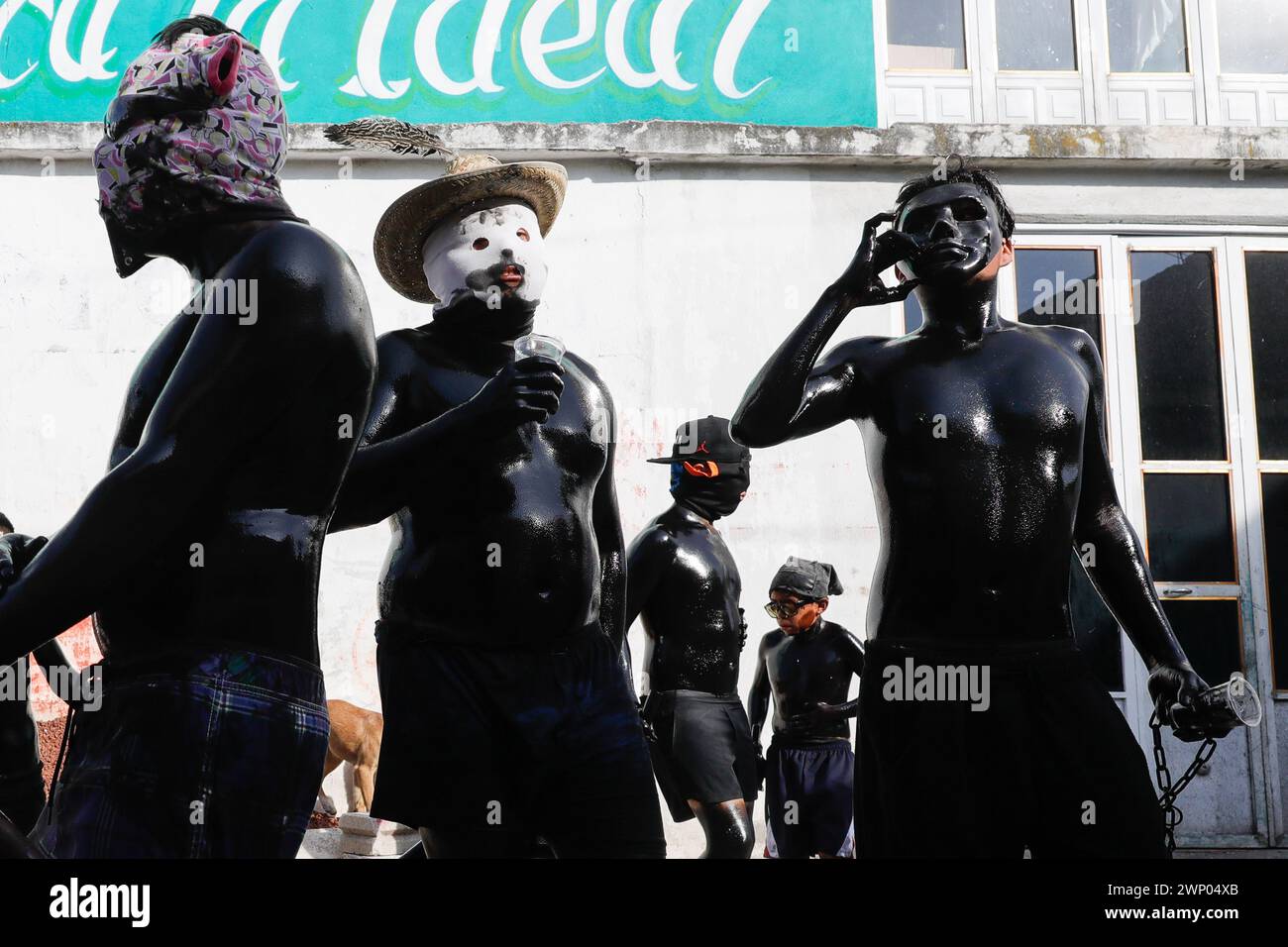 März 2024, San Nicolas de los Ranchos, Mexiko: Jugendliche mit schwarz lackiertem Körper und Masken nehmen an der vorspanischsprachigen Feier „der Karneval der Xinacates“ Teil, die in San Nicolas de los Ranchos, Gemeinde an den Hängen des Vulkans Popocatepetl, im Bundesstaat Puebla stattfindet. Als Teil der Tradition gehen die Xinacates oder gemalten Menschen auf die Straßen, um Touristen zu malen. Während dieser Feierlichkeiten wird dem Teoton-Vulkan Tribut gezollt, damit die Bewohner eine gute Erntezeit haben. Am 3. März 2024 in San Nicolas de los Ranchos, Mexiko. (Foto von es Stockfoto