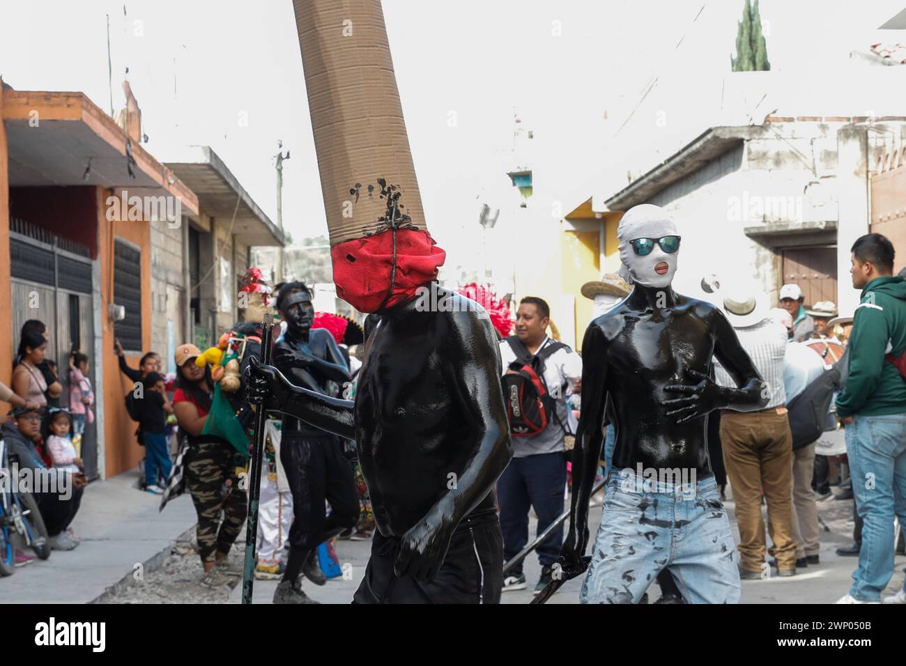 März 2024, San Nicolas de los Ranchos, Mexiko: Jugendliche mit schwarz lackiertem Körper und Masken nehmen an der vorspanischsprachigen Feier „der Karneval der Xinacates“ Teil, die in San Nicolas de los Ranchos, Gemeinde an den Hängen des Vulkans Popocatepetl, im Bundesstaat Puebla stattfindet. Als Teil der Tradition gehen die Xinacates oder gemalten Menschen auf die Straßen, um Touristen zu malen. Während dieser Feierlichkeiten wird dem Teoton-Vulkan Tribut gezollt, damit die Bewohner eine gute Erntezeit haben. Am 3. März 2024 in San Nicolas de los Ranchos, Mexiko. (Foto von es Stockfoto