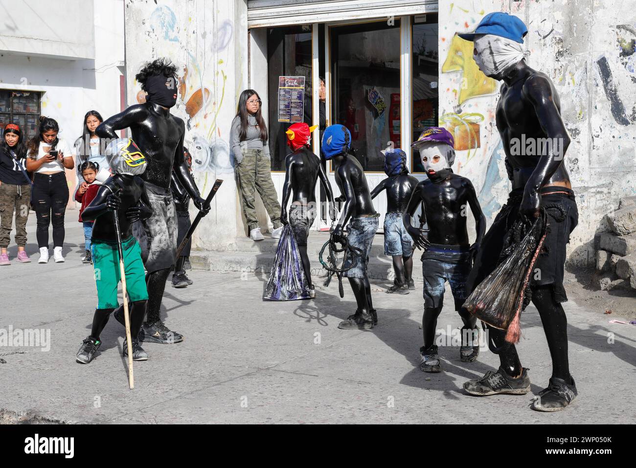 März 2024, San Nicolas de los Ranchos, Mexiko: Jugendliche mit schwarz lackiertem Körper und Masken nehmen an der vorspanischsprachigen Feier „der Karneval der Xinacates“ Teil, die in San Nicolas de los Ranchos, Gemeinde an den Hängen des Vulkans Popocatepetl, im Bundesstaat Puebla stattfindet. Als Teil der Tradition gehen die Xinacates oder gemalten Menschen auf die Straßen, um Touristen zu malen. Während dieser Feierlichkeiten wird dem Teoton-Vulkan Tribut gezollt, damit die Bewohner eine gute Erntezeit haben. Am 3. März 2024 in San Nicolas de los Ranchos, Mexiko. (Kredit-Imag Stockfoto