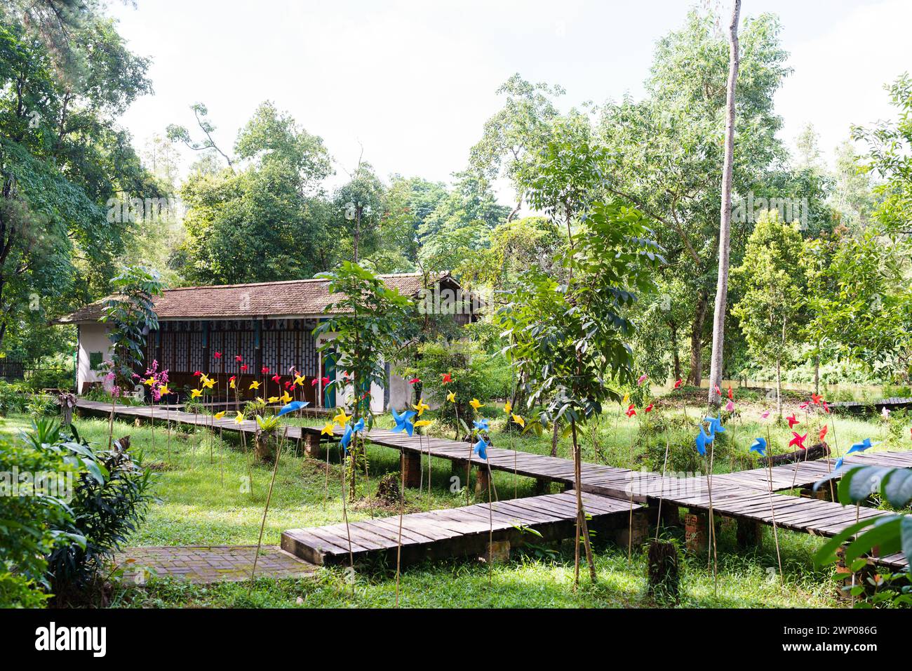 Blick auf ein Haus im japanischen Stil, das mit farbenfrohen Papierwindmühlen rund um den Hof dekoriert ist. Stockfoto