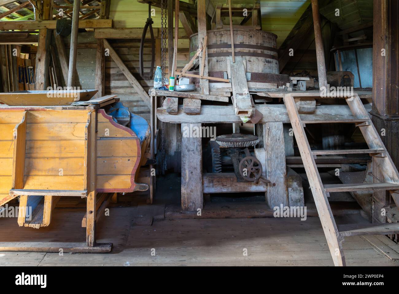 Das Innere einer alten Wassermühle. Alte Maschinen einer verlassenen Mühlenfabrik von innen. Stockfoto
