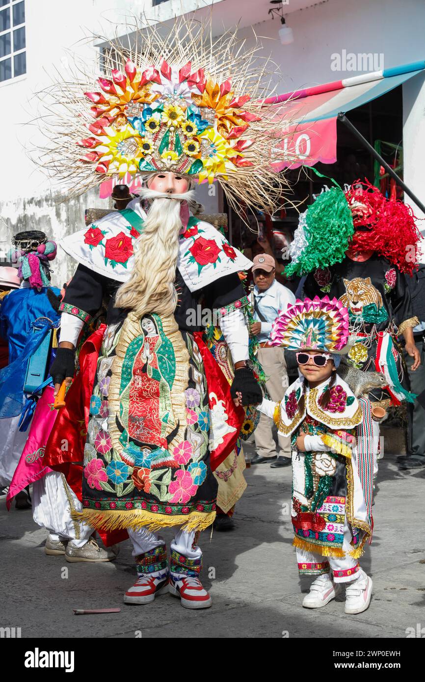 Nicht exklusiv: Ein Junge mit schwarz lackiertem Körper trägt eine Maske und nimmt an der vorspanischsprachigen festi „The Carnival of the Xinacates“ Teil Stockfoto