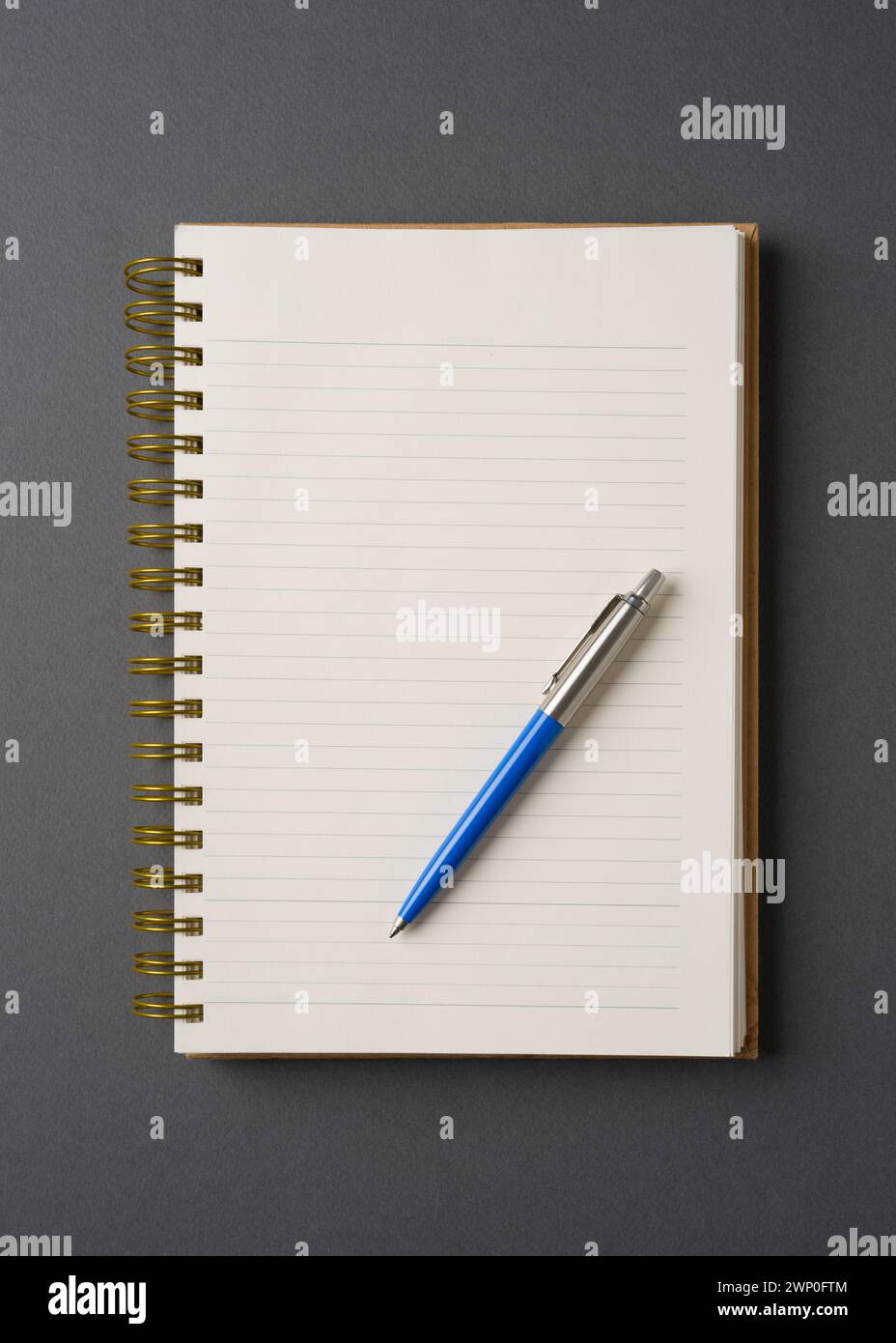 Kugelschreiber aus blauem Kunststoff und Metall auf gefüttertem Notebook Stockfoto