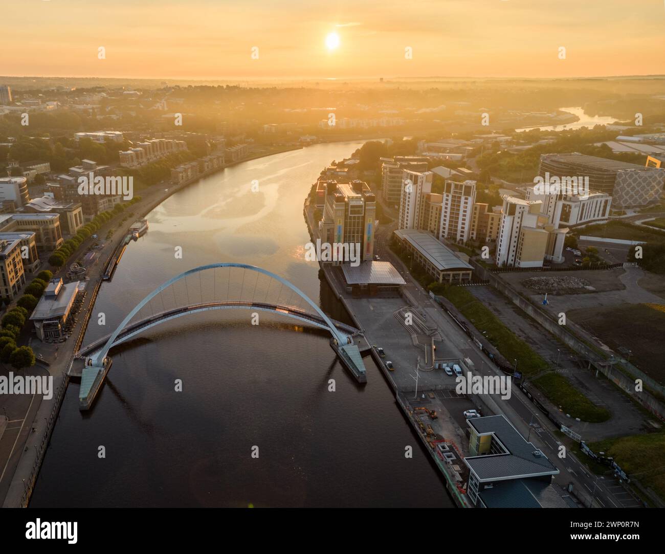Blick aus der Vogelperspektive nach Osten, während die Sonne an einem nebeligen Herbstmorgen über der Millennium Bride in Newcastle aufgeht Stockfoto