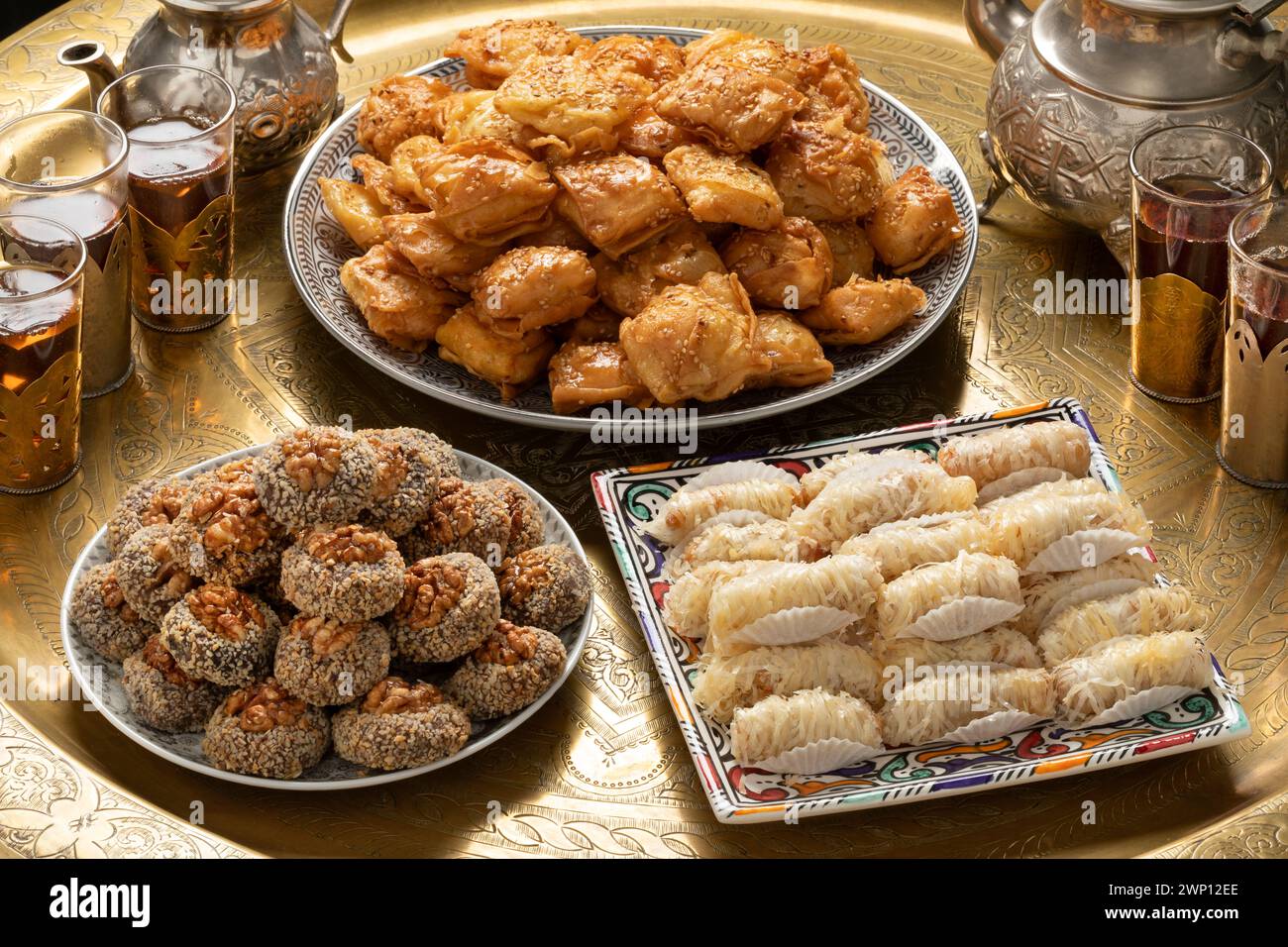 Traditioneller Teetisch aus marokkanischem Messing mit Tellern, Patisserie, Plätzchen und Tee Stockfoto