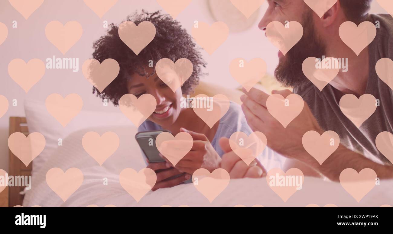 Bild von Herzen über glückliche, vielfältige Paare mit Smartphone Stockfoto