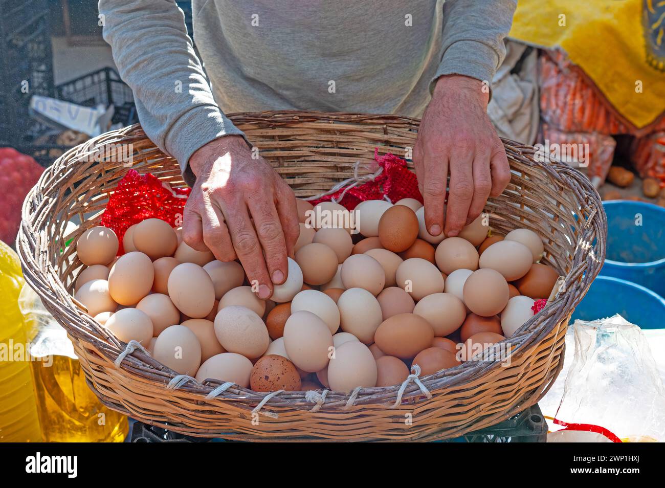 Ein Mann, der Eier in einem Korb auf dem Markt verkauft. Stockfoto