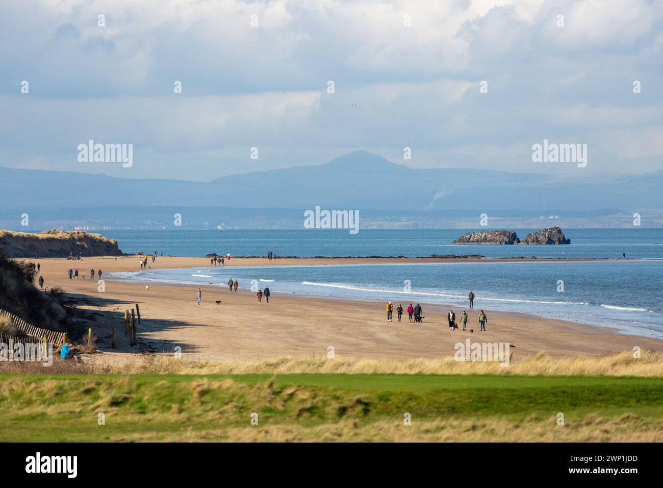 Menschen, die am Strand in der Nähe der Insel Fidra am Stadtrand von North Berwick, Schottland, spazieren gehen Stockfoto