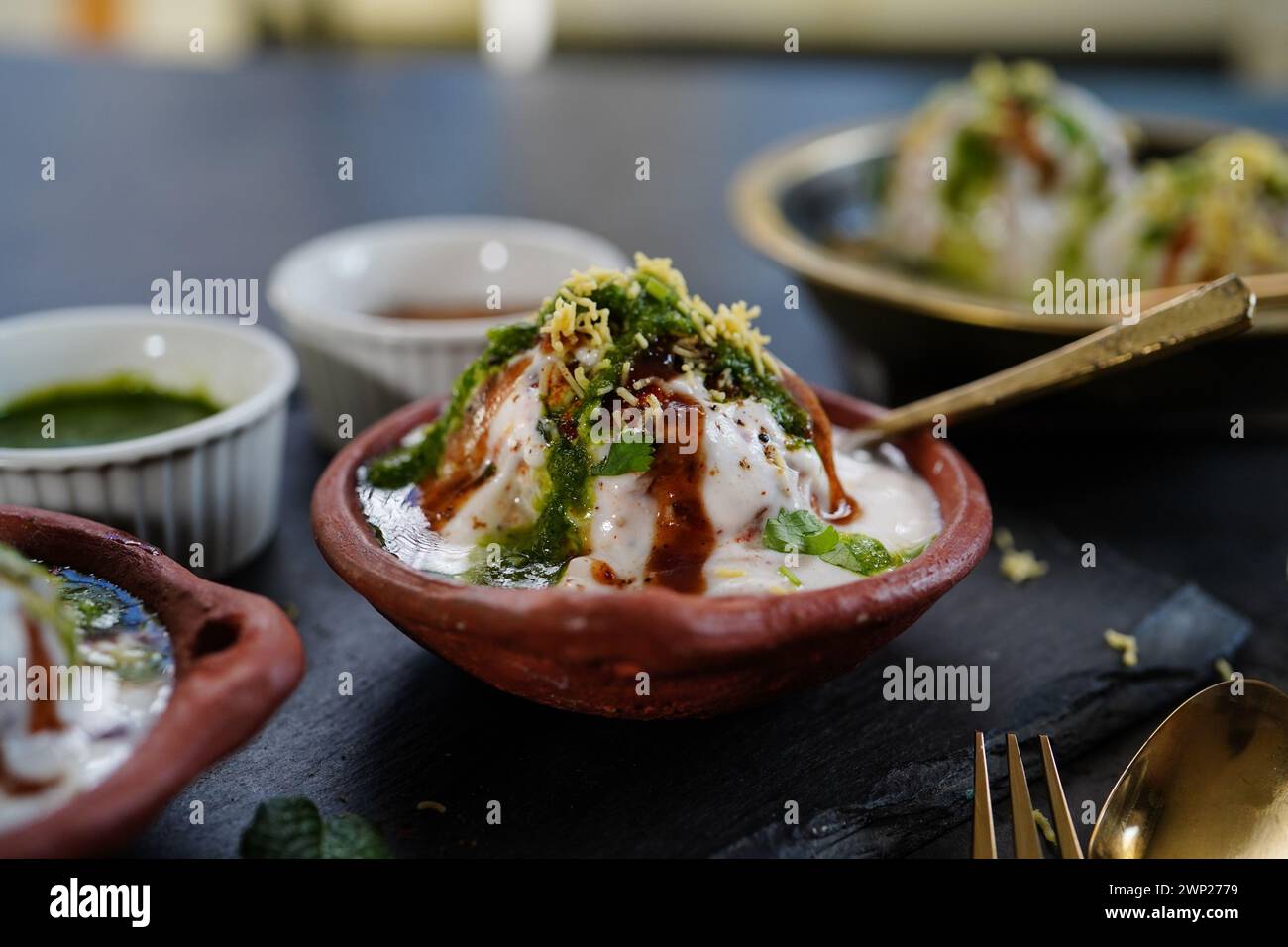 Hausgemachte Dahi Vada – nordindische Linsentrüppchen in Joghurt getränkt mit süßen und scharfen Chutneys Stockfoto