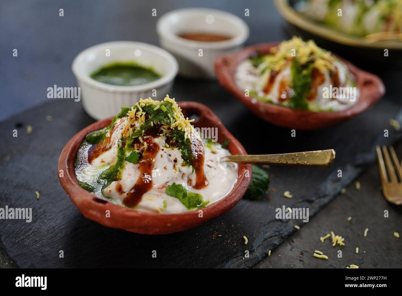 Hausgemachte Dahi Vada – nordindische Linsentrüppchen in Joghurt getränkt mit süßen und scharfen Chutneys Stockfoto