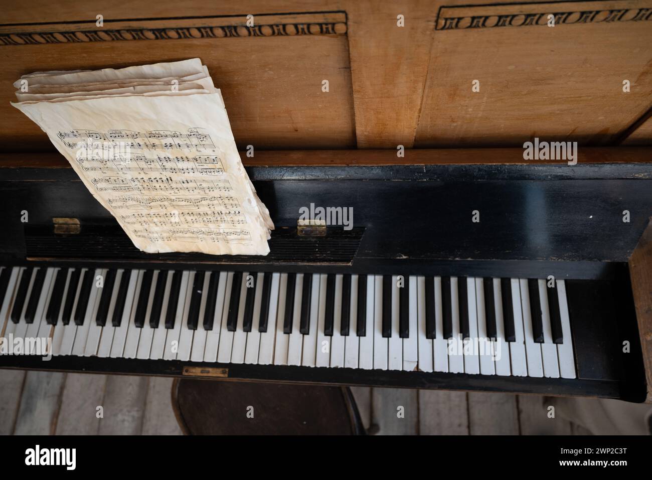 Schwarzes altes Klavier in Rissen mit Noten. Stockfoto