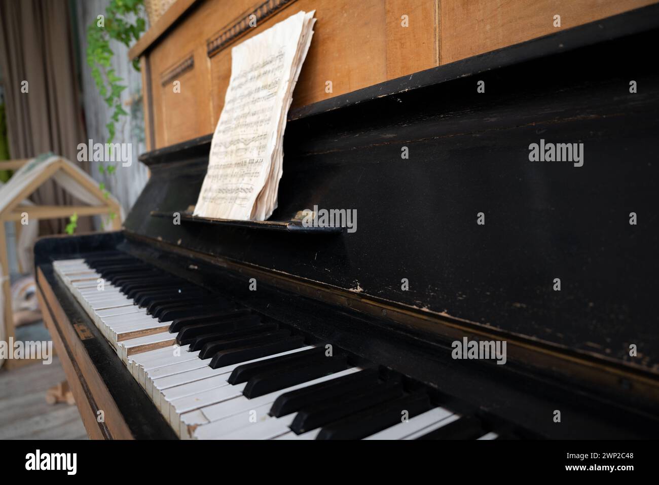 Schwarzes altes Klavier in Rissen mit Noten. Stockfoto