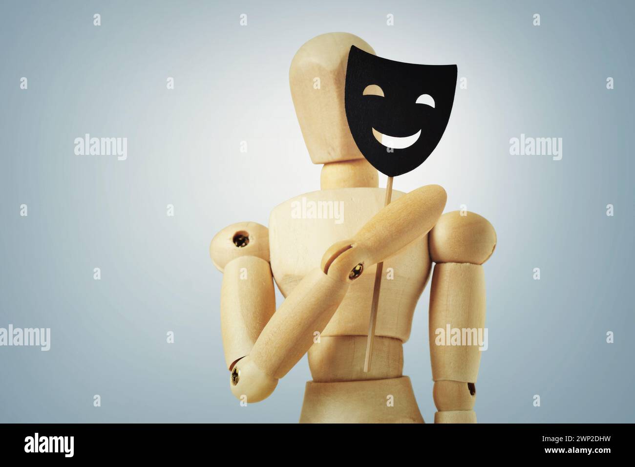 Holzpuppe, die Halbgesicht mit Maske verdeckt - Konzept der Psychologie und Maskierung der Persönlichkeit Stockfoto