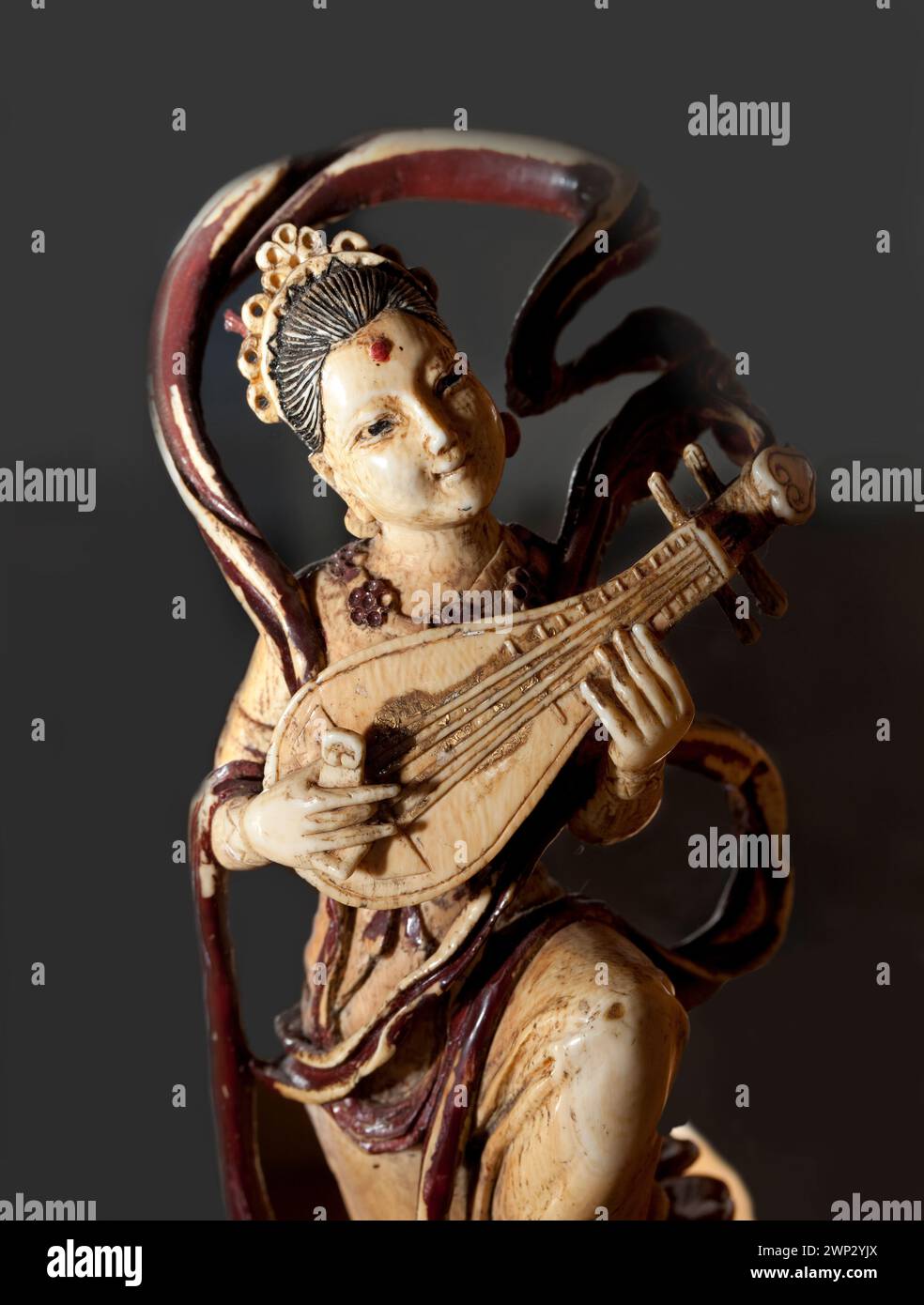 Geschnitzte Elfenbeinfigur, eine Frau, die eine Pipa spielt, traditionelle chinesische Laute Stockfoto