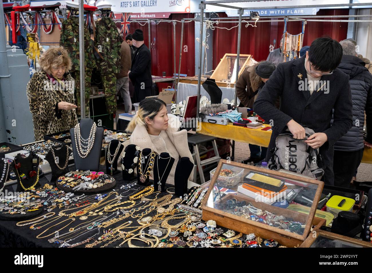 Verkaufsstände, Verkäufer und Kunden, die den Schmuck zum Verkauf auf dem Jubilee Market in Jubilee Hall, Covent Garden, am 4. März 2024 in London, Großbritannien, besichtigen. Jubilee Market ist ein überdachter Bereich in Covent Garden Piazza, der ein großer Anziehungspunkt für den Tourismus im West End ist. Montags ist der Markt auf Antiquitäten und Sammlerstücke spezialisiert. Stockfoto