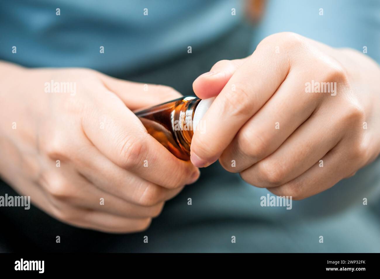 Die Hand einer Frau öffnet eine Flasche Medizin, Vitamine oder Nahrungsergänzungsmittel. Pflege der Gesundheit älterer Menschen Stockfoto