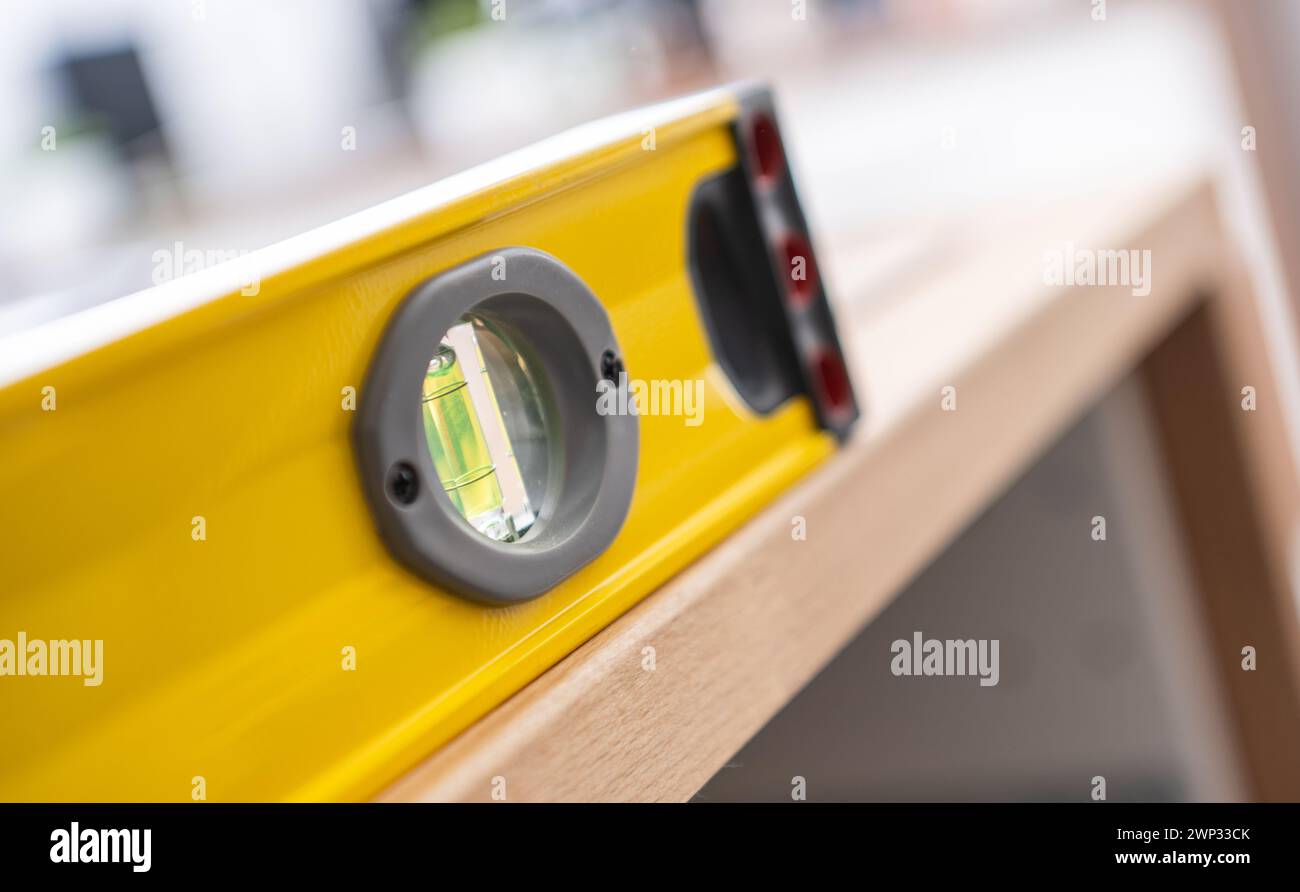 Gelbe professionelle Wasserwaage auf einer Holztheke. Möbelmontage. Stockfoto