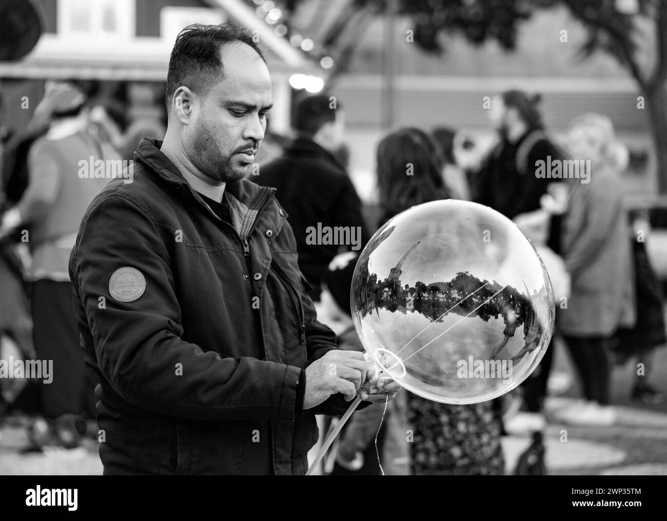 Mann, der Blasen auf dem jährlichen weihnachtsmarkt bläst Stockfoto