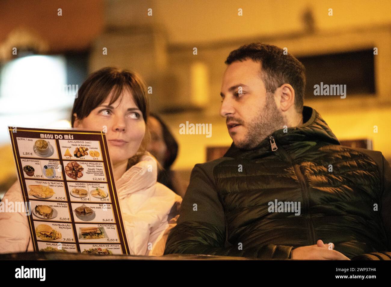 Ein Paar, das sich die Speisekarte in einem Restaurant anschaut. Mann und Frau schauen sich die Speisekarte an Stockfoto