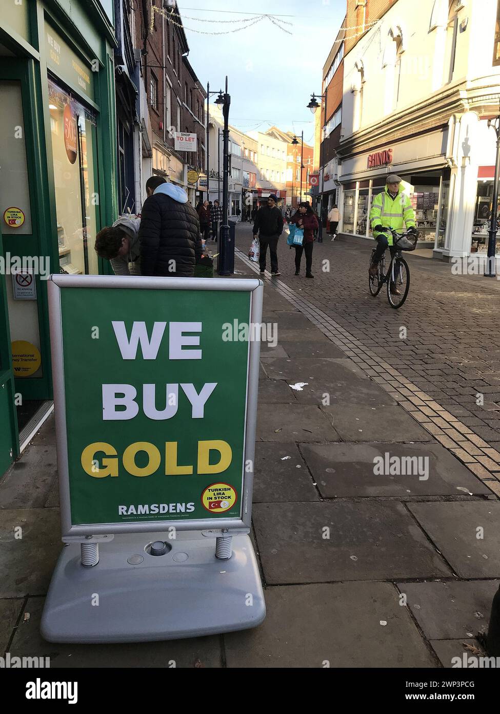Wir kaufen Gold-Schild auf dem Stadtviertel mit Leuten im Hintergrund. Boston Lincolnshire Stockfoto