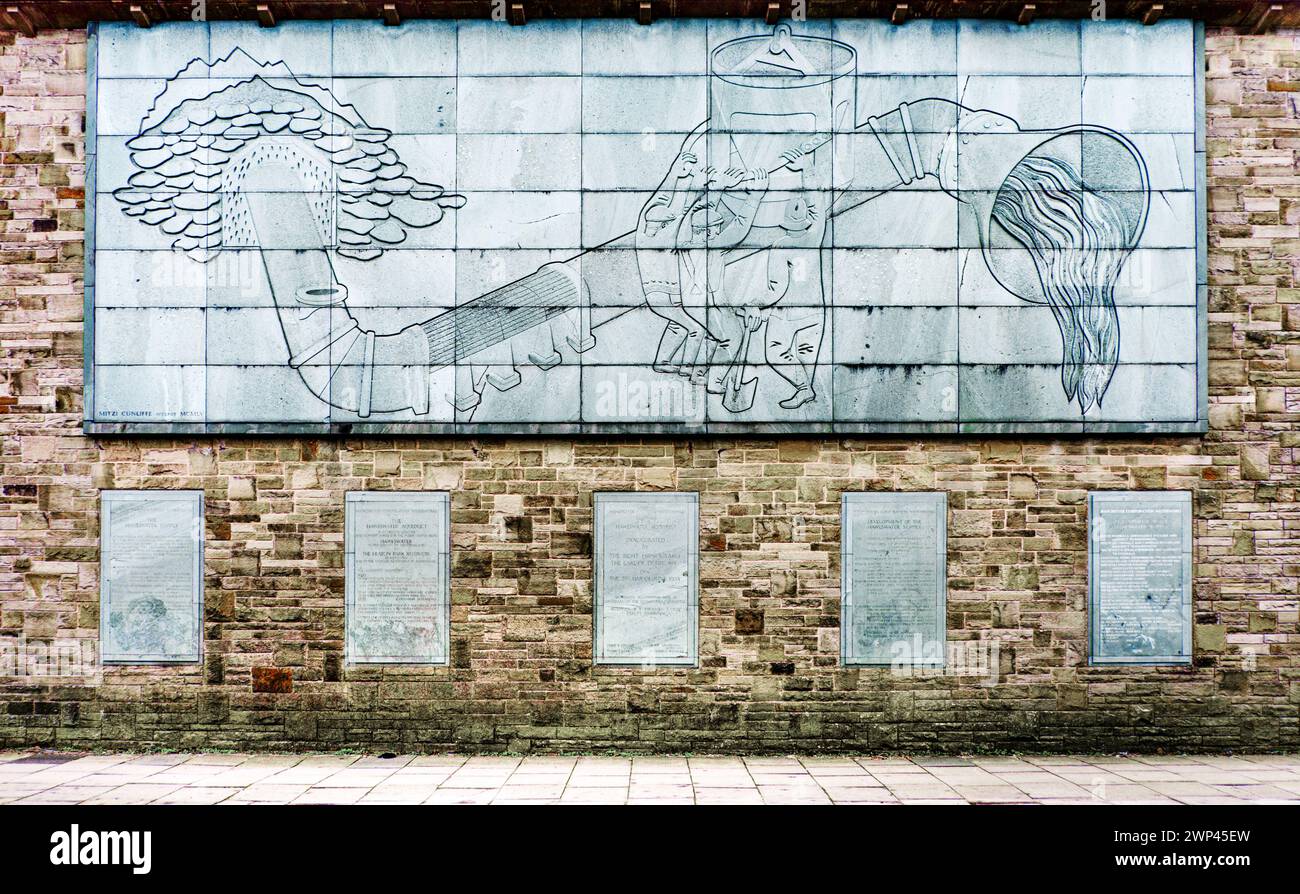 Reliefplatte von Mitzi Cunliffe auf der Pumpstation Heaton Park, die den Haweswater Aquaduct darstellt. Prestwich, Manchester, Großbritannien Stockfoto