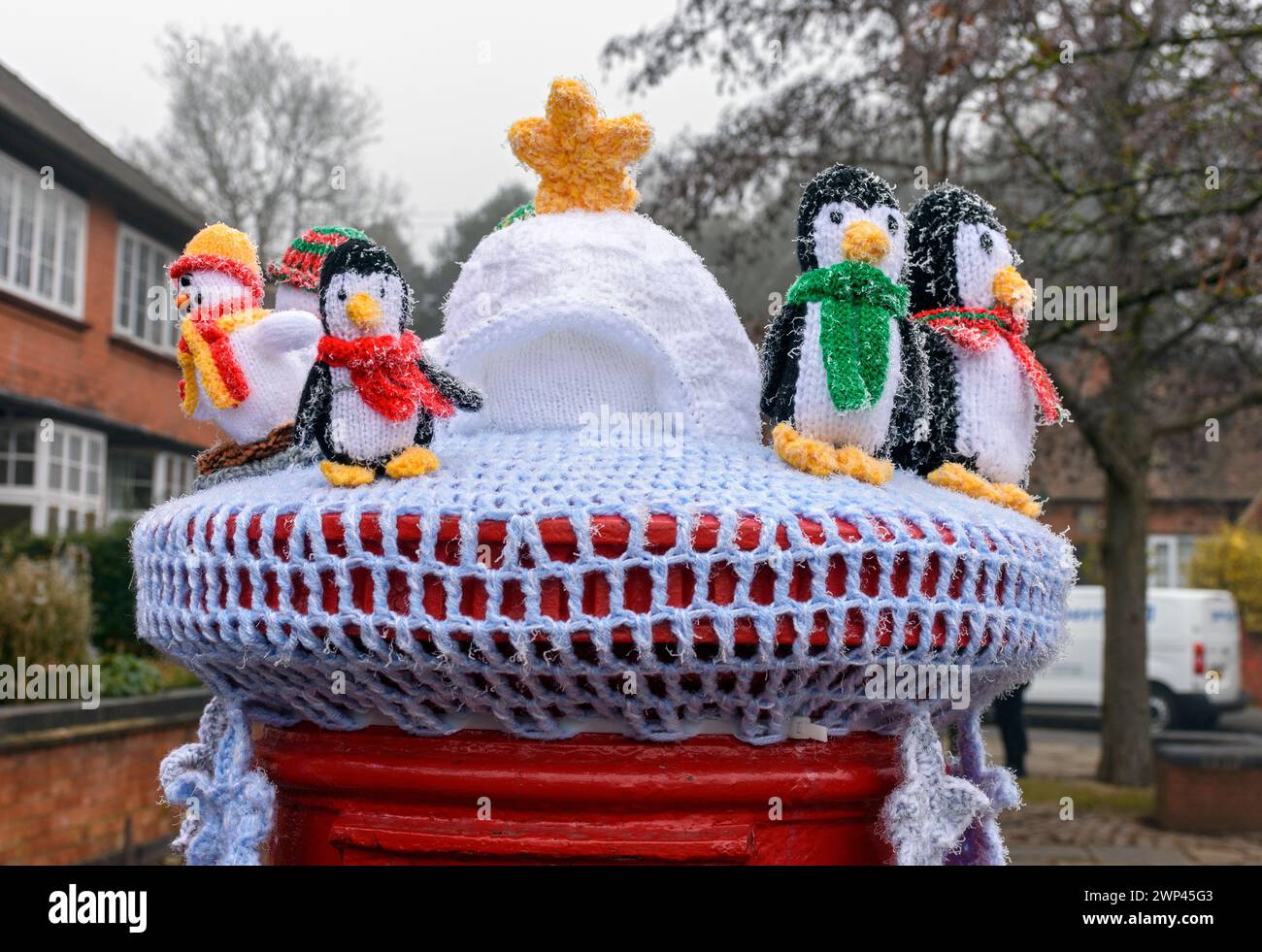 Gestrickter oder gestrickter Briefkasten mit Pinguinfiguren, einem Iglu und einem Stern. Auf dem Ruddington Christmas Market, Nottinghamshire, Großbritannien Stockfoto