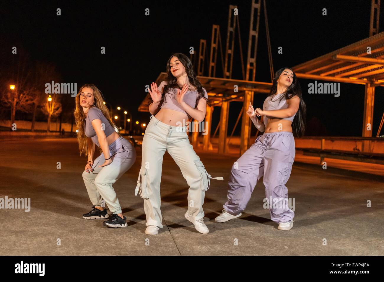 Junge Tanzkompanie, die nachts auf der Straße Hip-Hop-Tanz aufführt Stockfoto