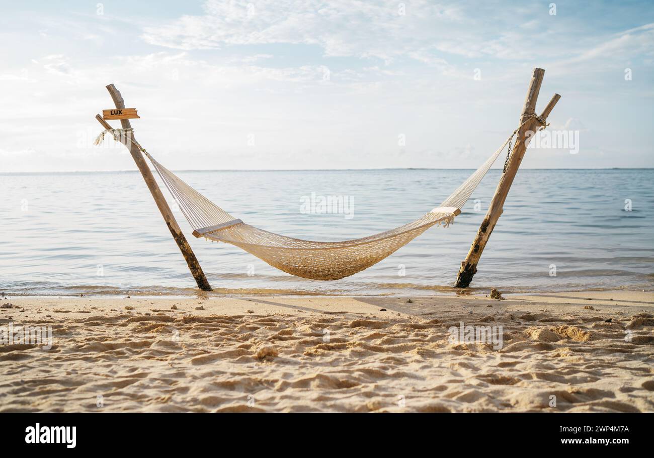 Hängematten-Netz am seichten Sandstrand auf der Halbinsel Le Morne, Mauritius. Ruhiger Sonnenuntergang wunderschönes Urlaubsfoto... Stockfoto