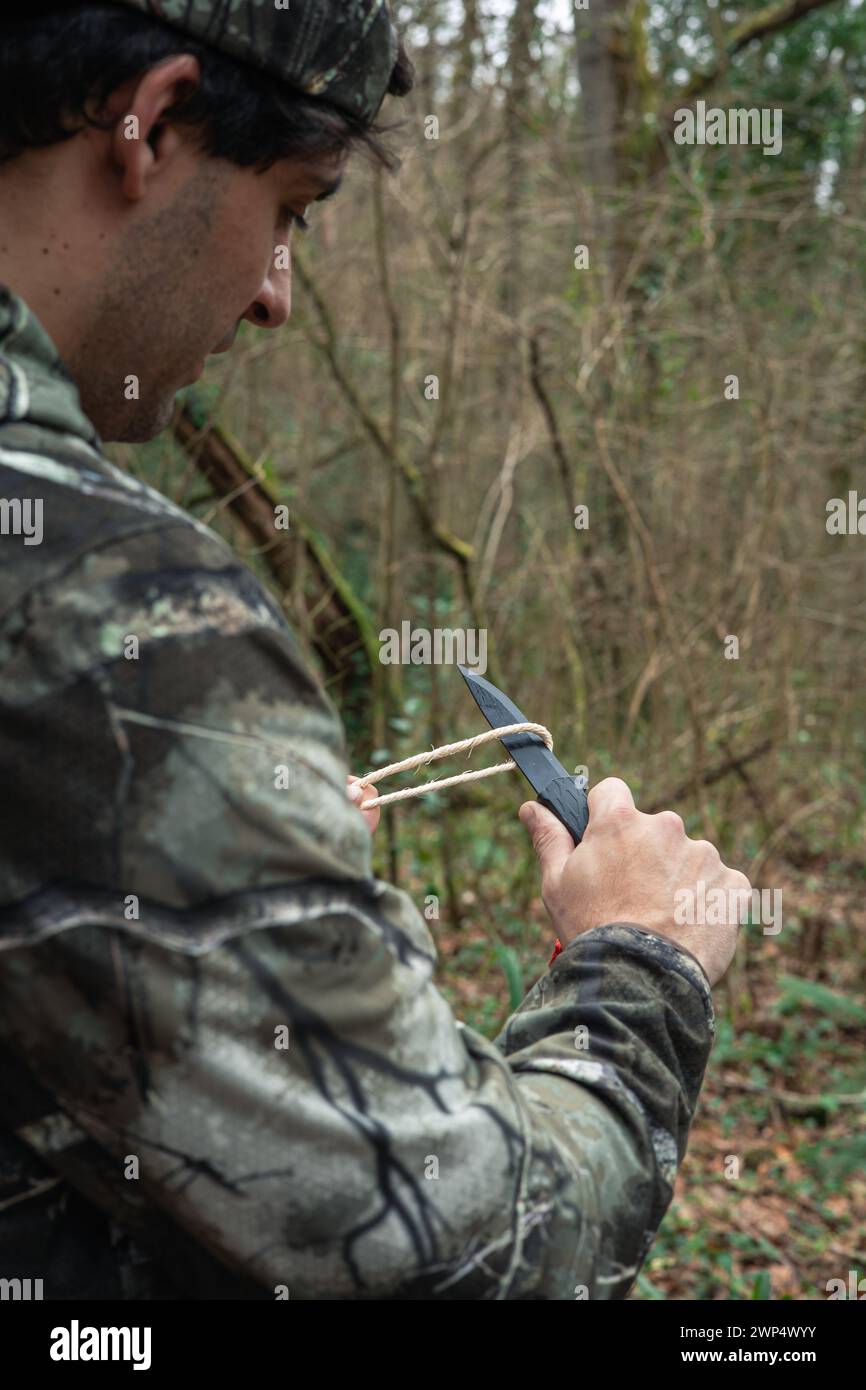 Nahaufnahme von hinten in diesem beeindruckenden Bild taucht ein unerschrockener Entdecker mitten im Wald ein und stellt sich Herausforderungen mit Geschick und Tapferkeit. Arm Stockfoto