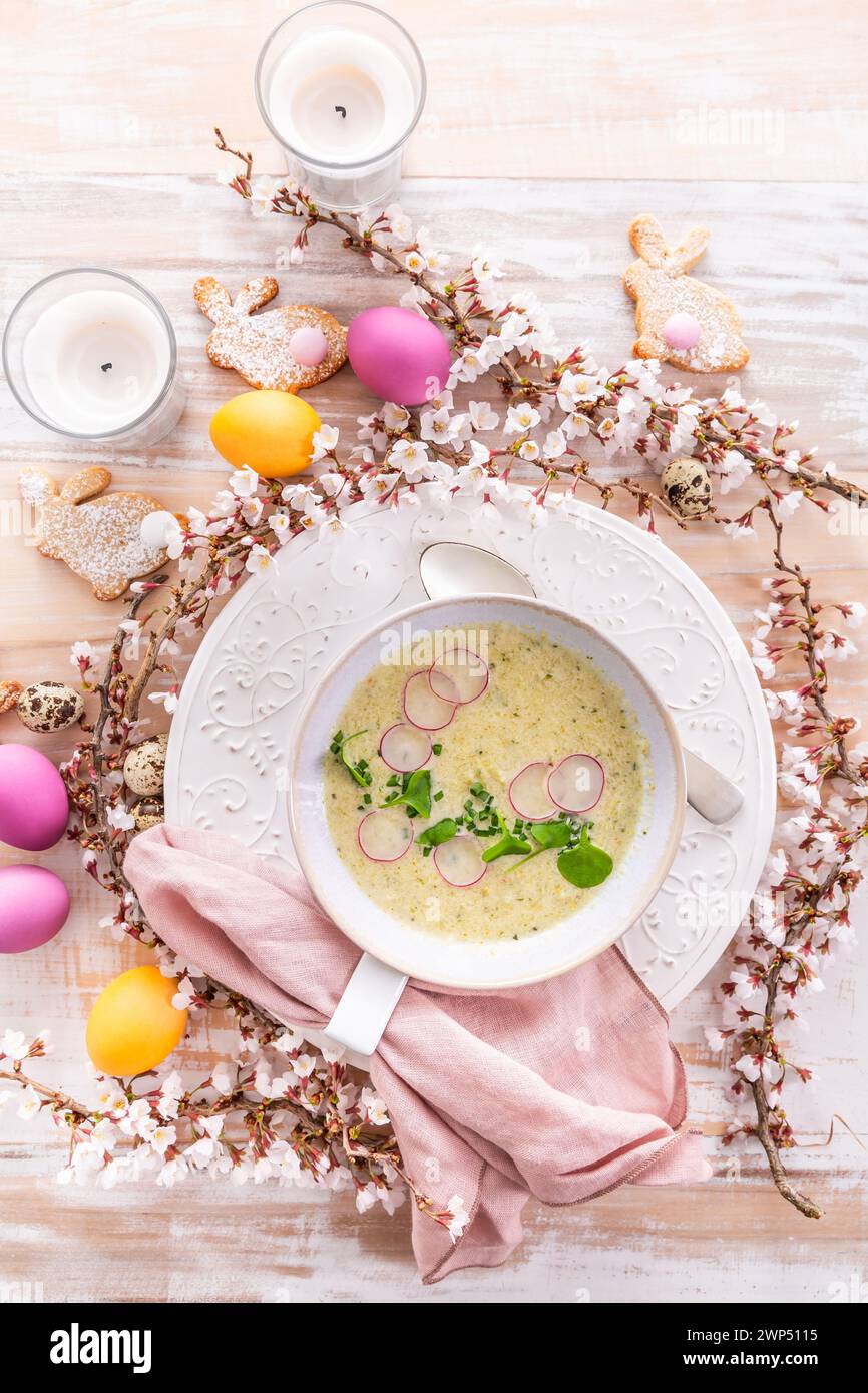 Gemüsesuppe mit Zucchini, Blumenkohl und Rettich zu Ostern mit bunten Eiern Stockfoto