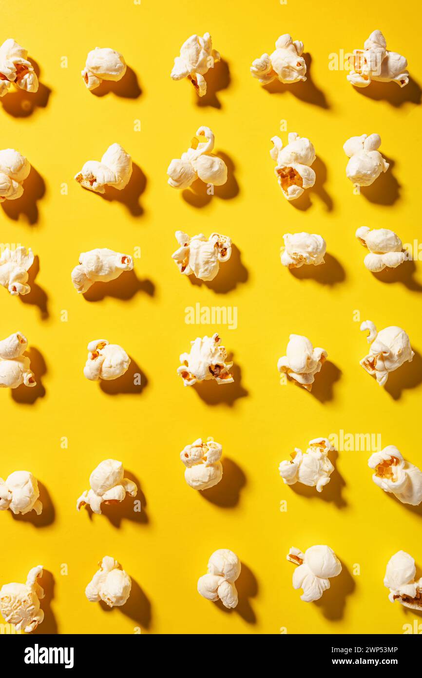 Leckeres frisches Popcorn auf gelbem Hintergrund, Draufsicht Stockfoto