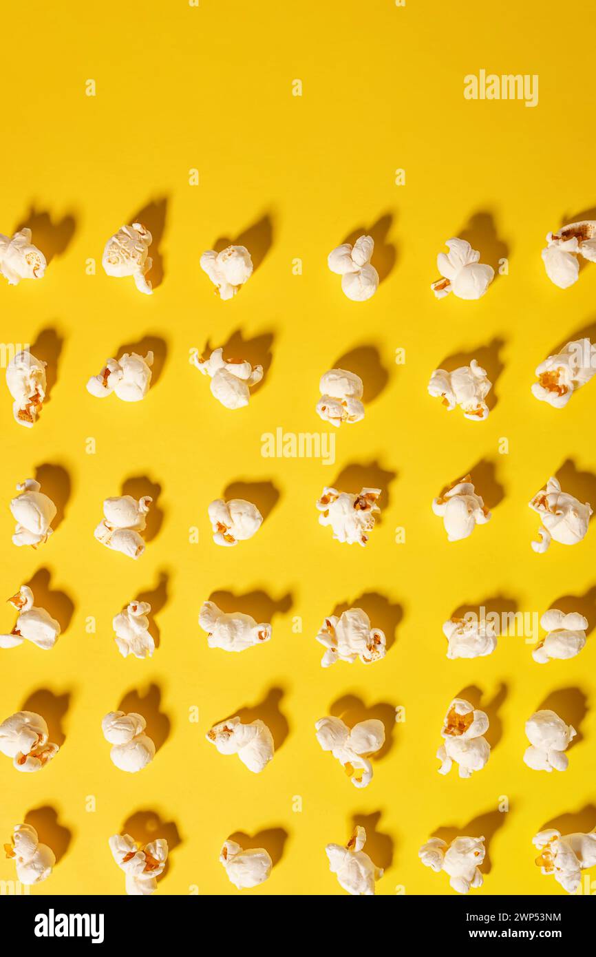 Leckeres frisches Popcorn auf gelbem Hintergrund, Draufsicht Stockfoto