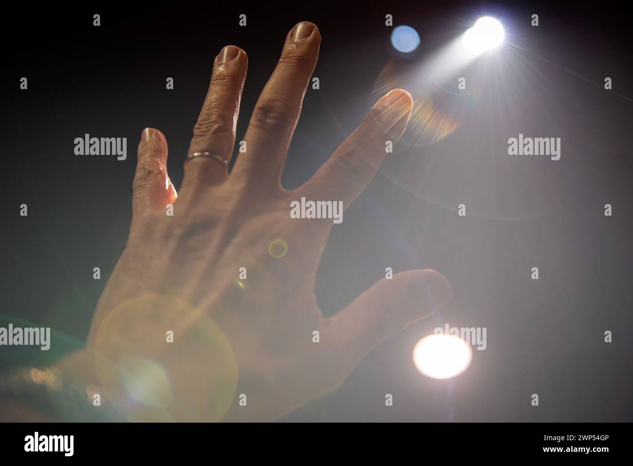 Die Hand des Mannes greift nach den Lichtern. Stockfoto