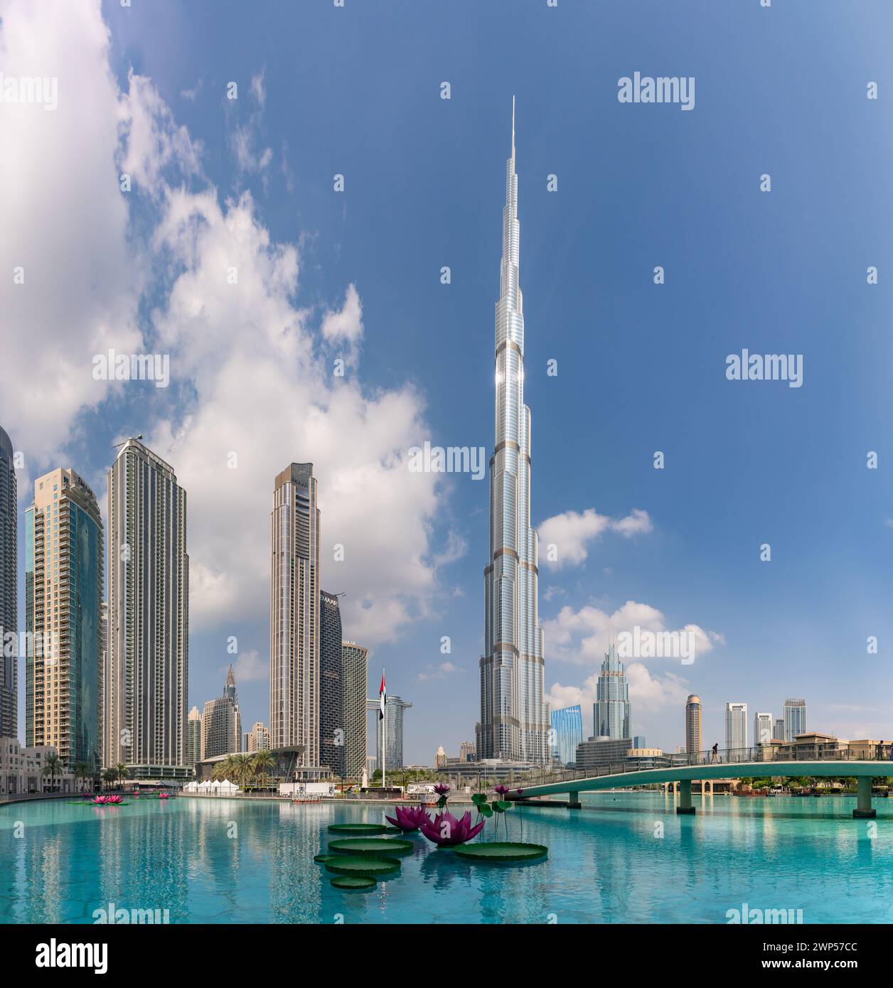 Ein Bild des Burj Khalifa, der die nahe gelegenen Gebäude in der Innenstadt von Dubai und das blaue Wasser des Burj Khalifa Lake überragt. Stockfoto