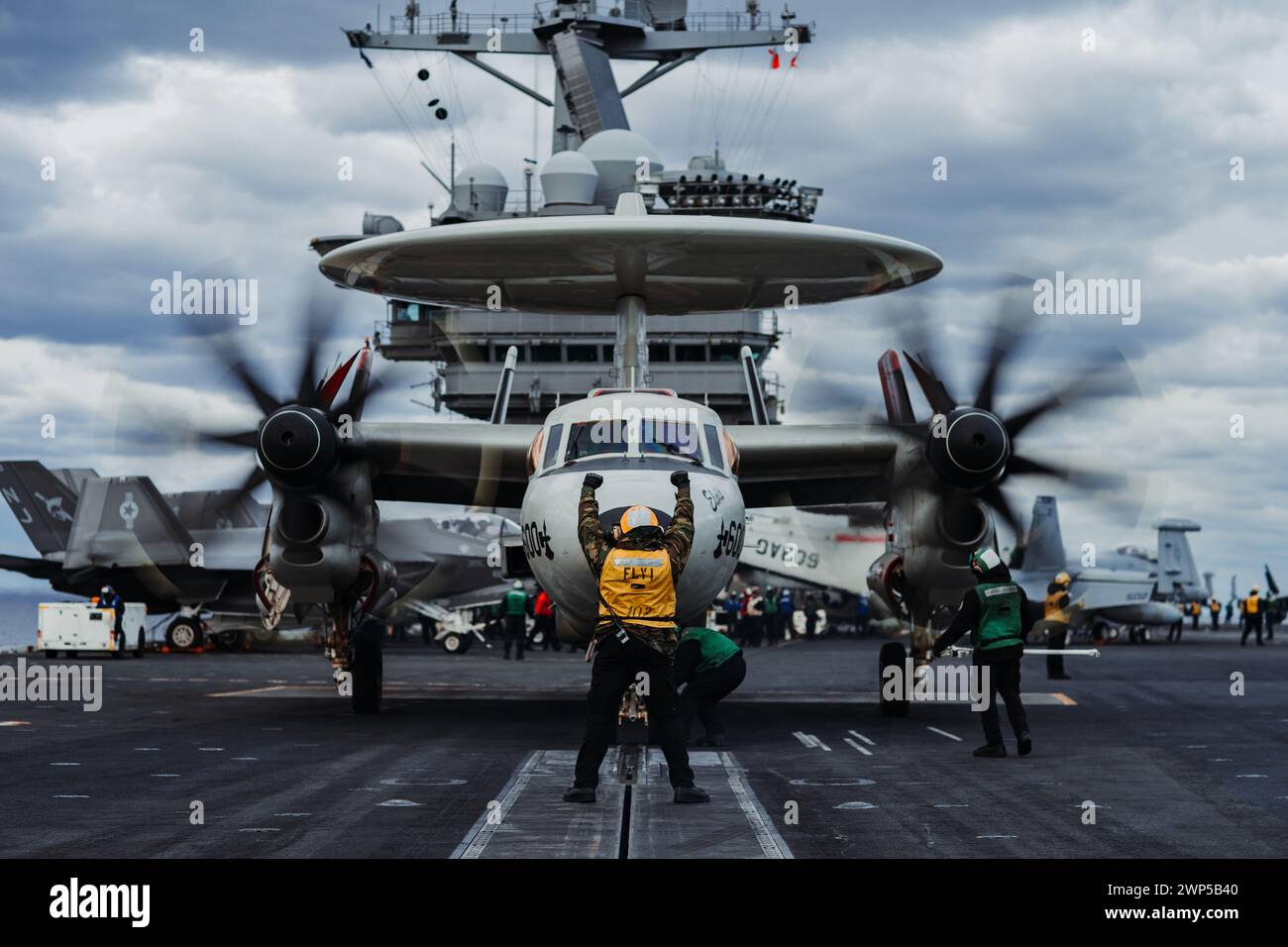 Devon Swopes aus Little Rock, Arkansas, der der V-1-Division des Luftministeriums zugeteilt ist, signalisiert am 1. März 2024 eine E-2C Hawkeye, die an der Airborne Command and Control Squadron (VAW) 116 befestigt ist, um auf dem Flugzeugträger der Nimitz-Klasse USS George Washington (CVN 73) im Atlantik festzuhalten. George Washington führt TSTA/FEP (Tailored Ships Training Availability and Final Evaluation Problem) durch. TSTA bereitet das Schiff und die Besatzung auf die vollständige Integration in eine Trägerstreikgruppe durch eine Vielzahl von missionskritischen Operationen vor. (Foto der U.S. Navy von Mass Communicatio Stockfoto