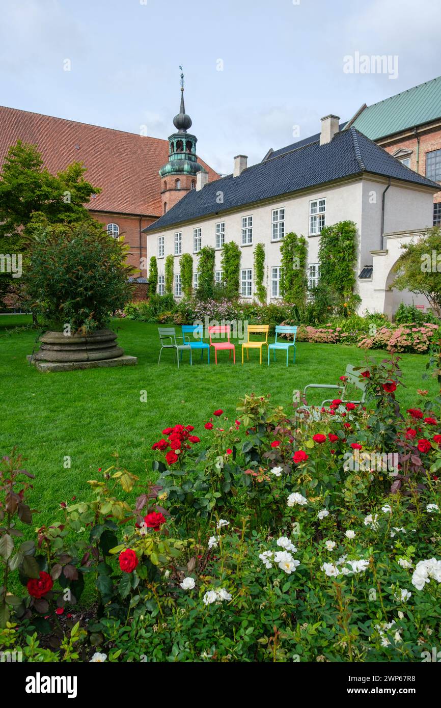 Kopenhagen, Dänemark 03. Oktober 2023 - fünf Stühle in einem Regenbogen von Farben auf Gras zwischen Blumen im Royal Library Garden, Slotsholmen, Kopenhagen Stockfoto