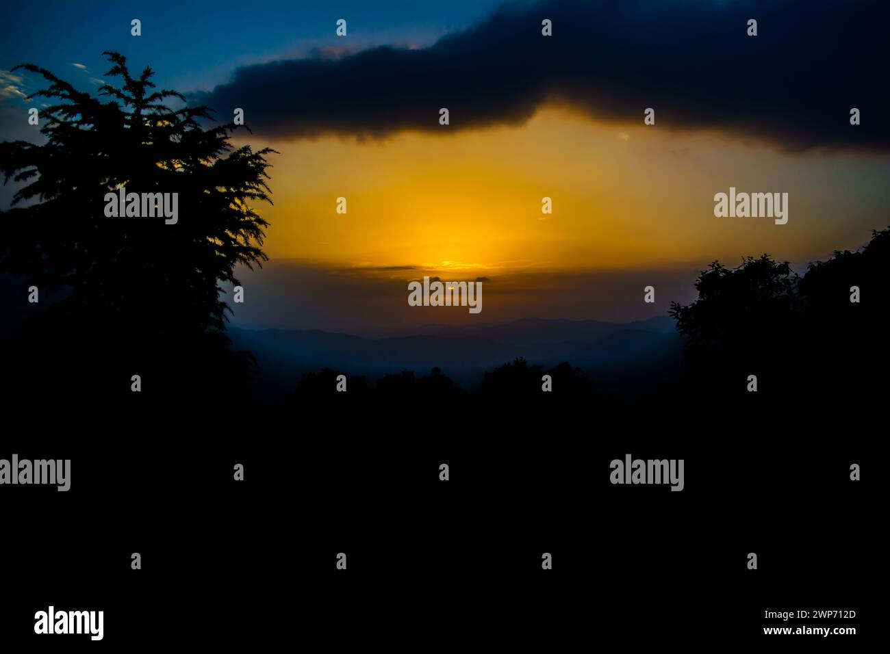 Blick auf den Sonnenuntergang von den Bergen von Lansdowne. Blick auf den Sonnenuntergang in Lansdowne. Fantastischer goldener Sonnenuntergang durch die Waldfahrt, Lansdowne Uttarakhan Stockfoto