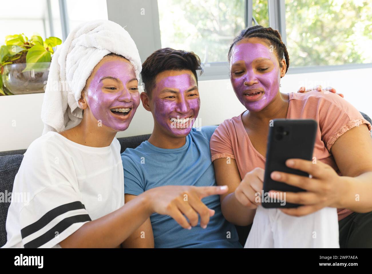Drei Freunde genießen einen Spa-Tag zu Hause, lachen und machen Selfies Stockfoto