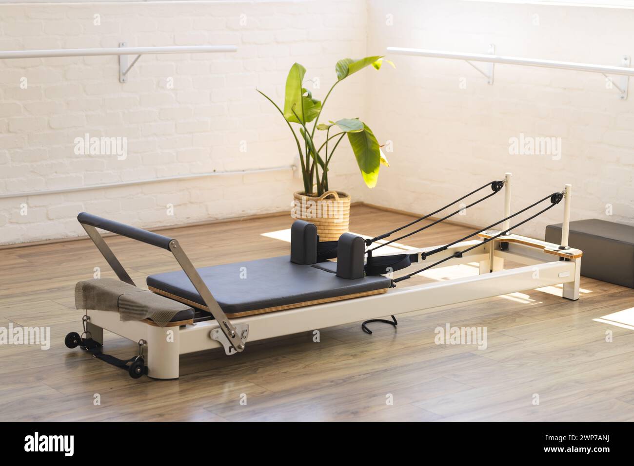 Ein Pilates-Reformator ist bereit für ein Workout in einem hellen Studio Stockfoto