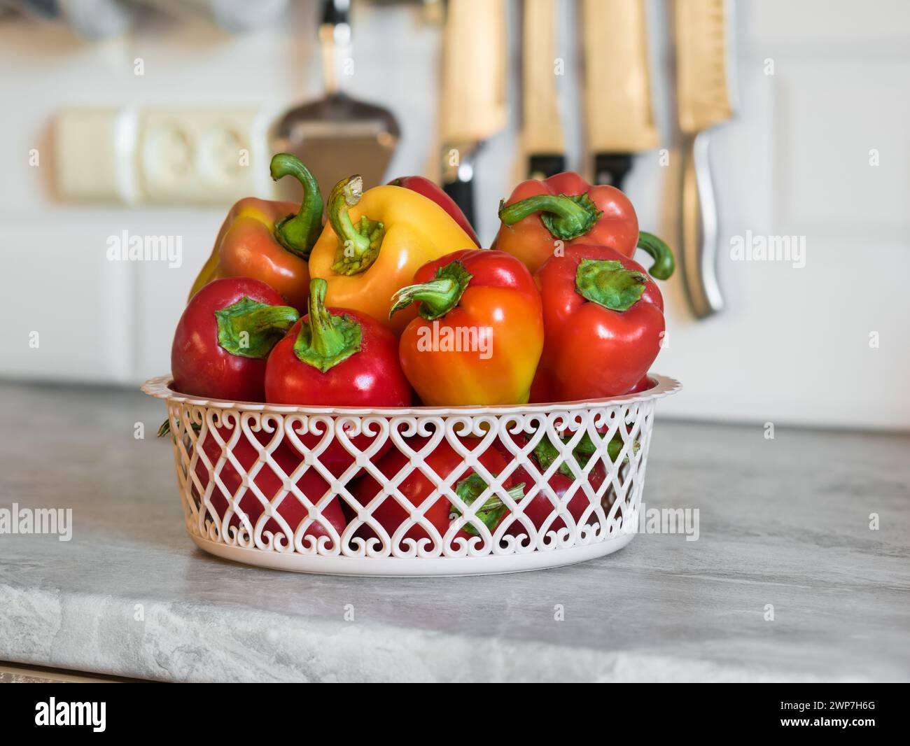 Rote und gelbe Paprika (Paprika, Paprika, Paprika) in einem Korb auf der Küchentheke Stockfoto
