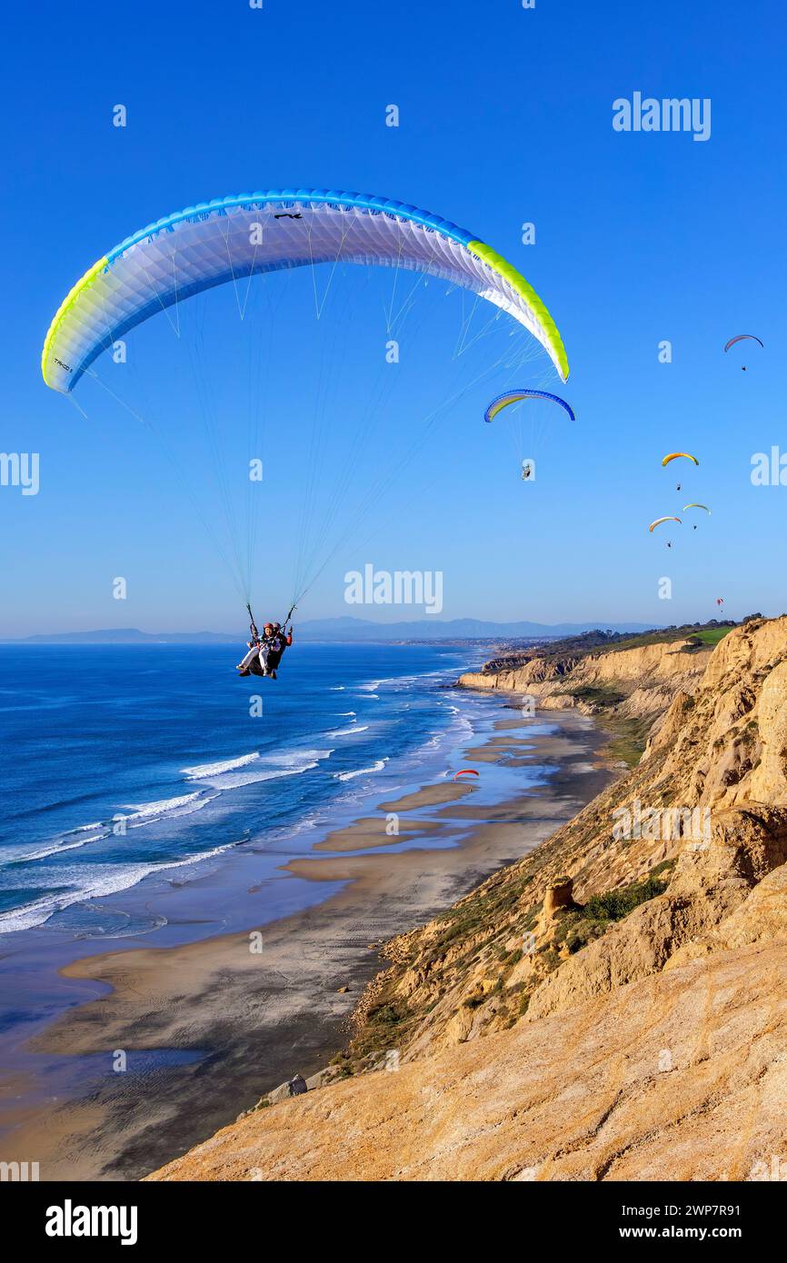 Mehrere Gleitschirmflieger fliegen über die Klippen in San Diego, Kalifornien Stockfoto
